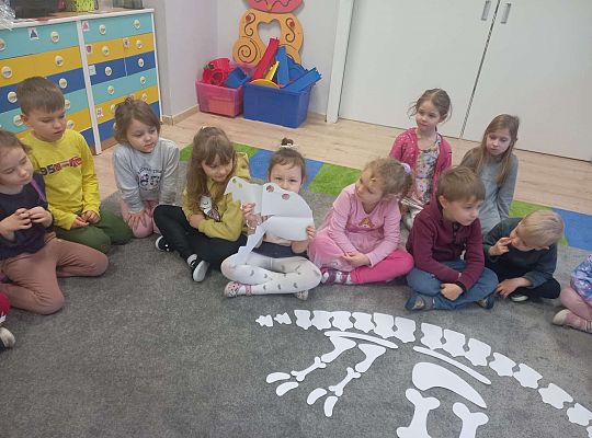 Dzieci układają kości dinozaura