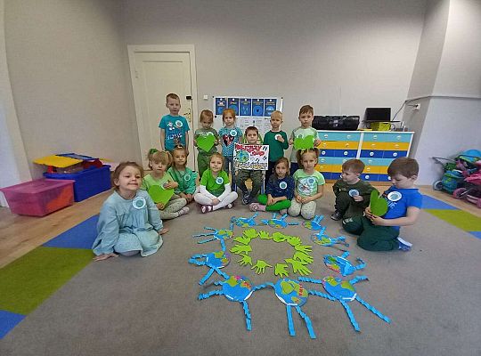Grupa dzieci prezentuje prace plastyczne