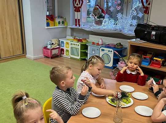 Dzieci wspólnie jedzą urodzinowe owoce