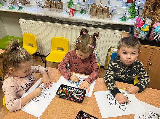 Dzieci kolorują prezent dla jubilatki