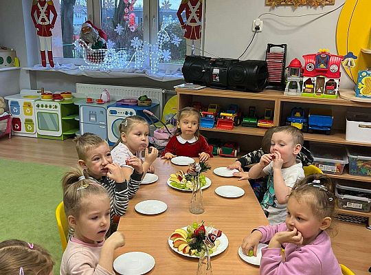 Dzieci wspólnie jedzą urodzinowe owoce