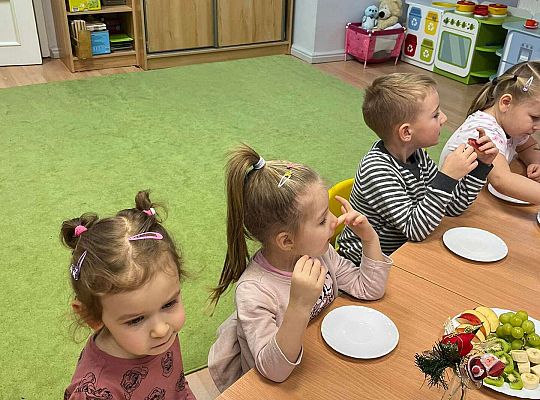 Dzieci wspólnie jedzą urodzinowe owoce