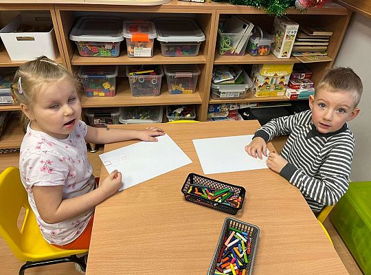 Dzieci kolorują prezent dla jubilatki