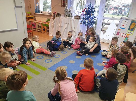 Mama Nadii czyta dzieciom, które siedzą na dywanie