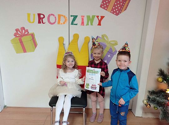 Dzieci wręczają jubilatce album urodzinowy