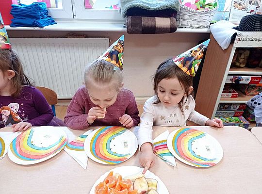 Dzieci jedzą urodzinowe owoce