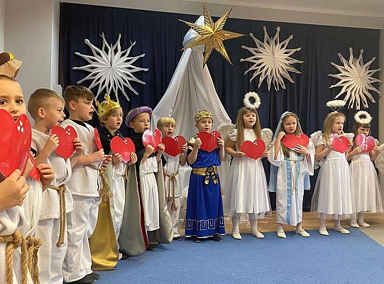 Dzieci z serduszkami przed sobą śpiewają piosenkę