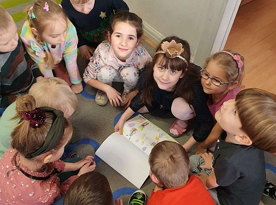 Kornelka ogląda swój prezent urodzinami z koleżankami i kolegami