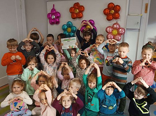 Olek na zdjęciu grupowym a dzieci robią serduszka z dłoni