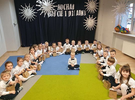 Grupa dzieci z prezentami pożegnalnymi od kolegi