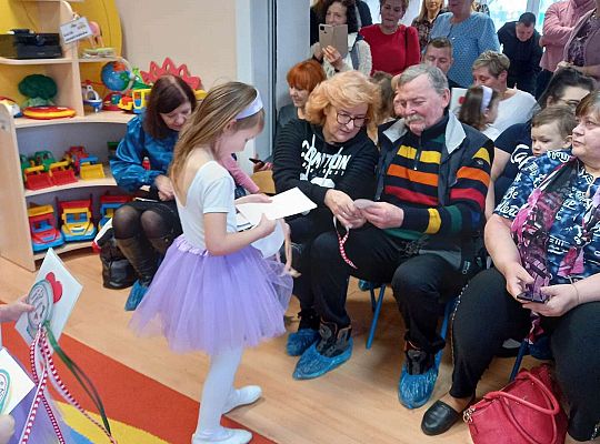 Dzieci wręczają upominki zaproszonym babciom i dziadkom