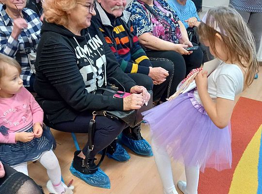 Dzieci wręczają upominki zaproszonym babciom i dziadkom