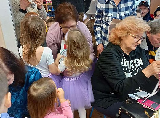 Dzieci wręczają upominki zaproszonym babciom i dziadkom