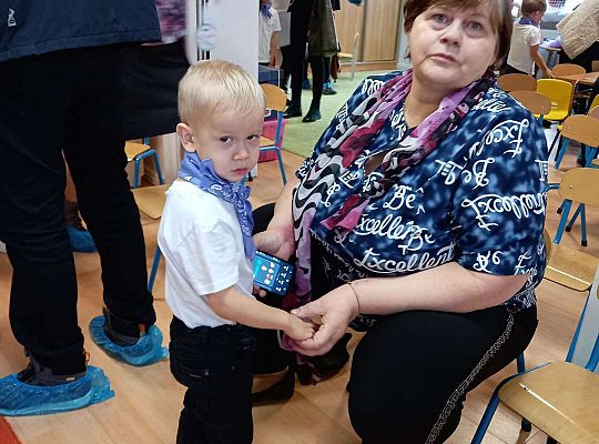 Dzieci wręczają upominki zaproszonym babciom i dziadkom