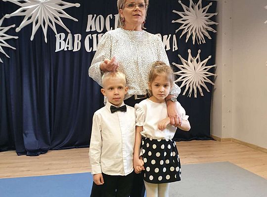 Chłopiec i dziewczynka razem z Panią Dyrektor która wita gości