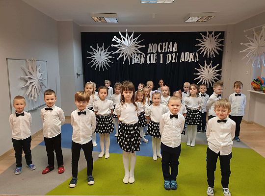 Chłopcy i dziewczynki stoją w rozsypce i śpiewają