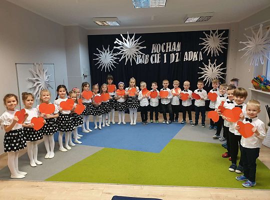 Grupa dzieci trzyma przed sobą serduszka