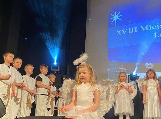 Dziewczynka przebrana za aniołka gra na cymbałkach