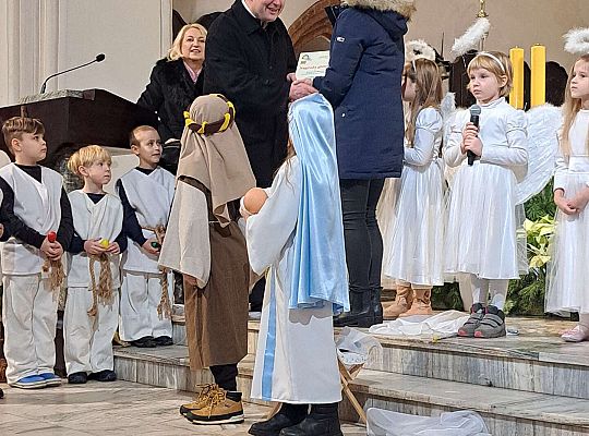 wręczenie dyplomu z podziękowaniem od księdza dla dzieci za występ na ręce nauczycielki