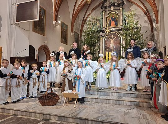 Zdjęcie grupowe dzieci i nauczycielek przed ołtarzem w kościele