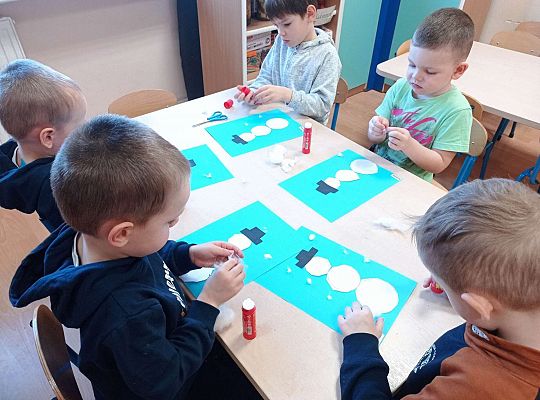 Dzieci wycinają kółka oraz przyklejają tak aby powstał bałwanek