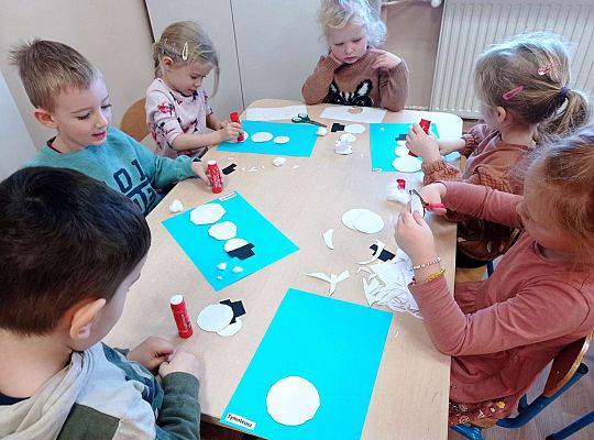 Dzieci wycinają kółka oraz przyklejają tak aby powstał bałwanek