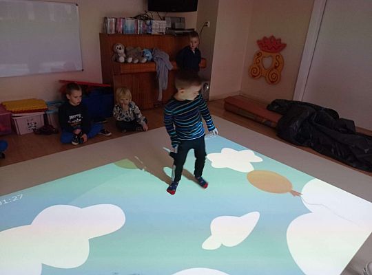 Dzieci zbijają balony naskakując na nie