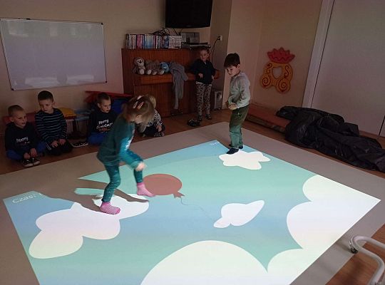 Dzieci zbijają balony naskakując na nie