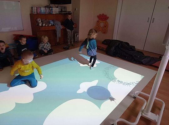 Dzieci zbijają balony naskakując na nie