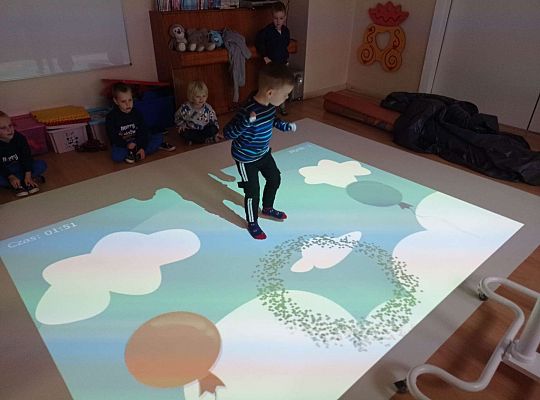 Dzieci zbijają balony naskakując na nie