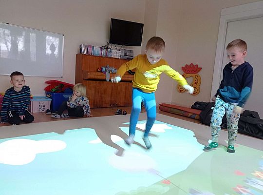 Dzieci zbijają balony naskakując na nie