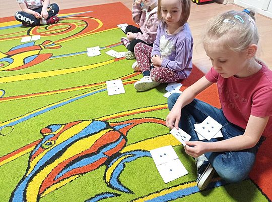 Dzieci przeliczają kropki na kartkach