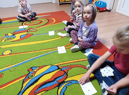 Dzieci przeliczają kropki na kartkach