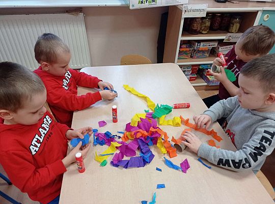 Dzieci wykonują instrument muzyczny z rolki po papierze toaletowym