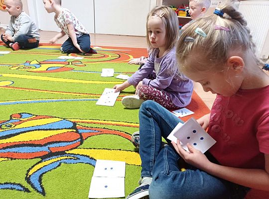 Dzieci przeliczają kropki na kartkach