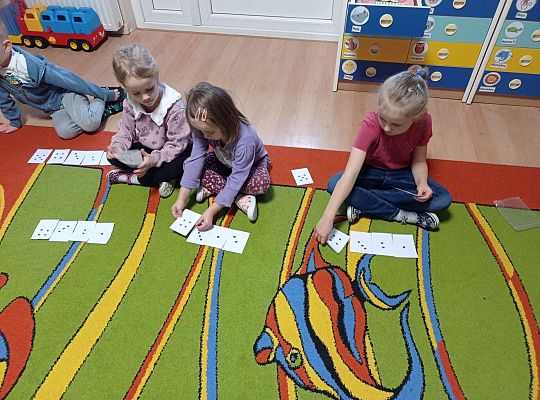 Dzieci przeliczają kropki na kartkach