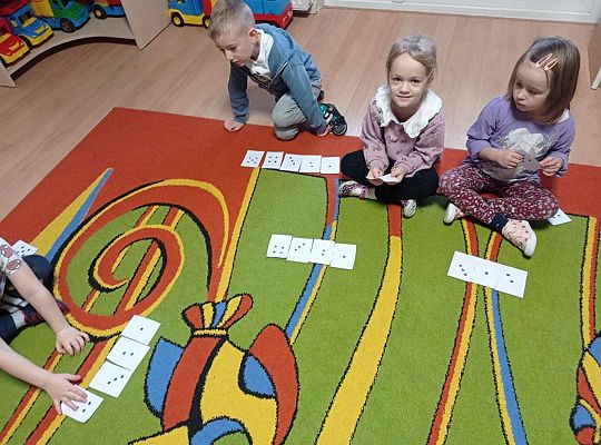 Dzieci przeliczają kropki na kartkach