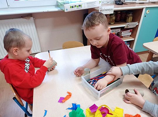 Dzieci wykonują instrument muzyczny z rolki po papierze toaletowym