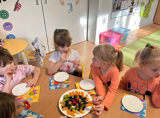 Dzieci jedzą urodzinowe owoce