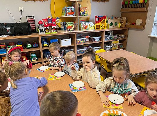 Dzieci jedzą urodzinowe owoce