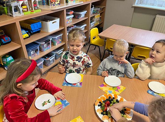 Dzieci jedzą urodzinowe owoce