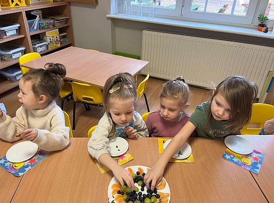 Dzieci jedzą urodzinowe owoce