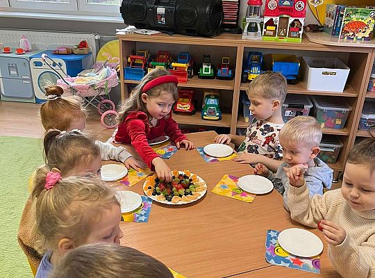 Dzieci jedzą urodzinowe owoce