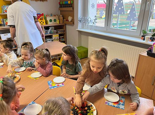 Dzieci jedzą urodzinowe owoce