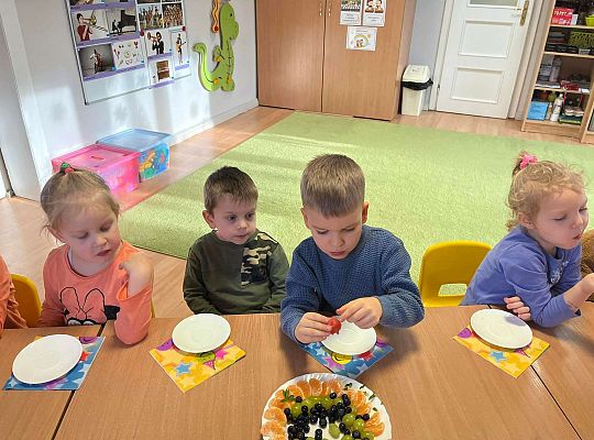 Dzieci jedzą urodzinowe owoce