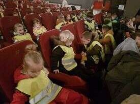 Dzieci zajmują miejsca na fotelach przed przedstawieniem