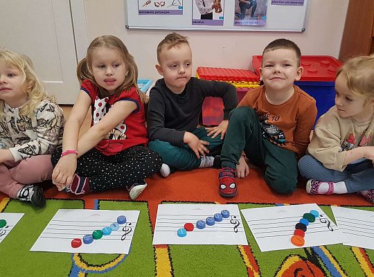 Dzieci układają zakrętki na pięciolinii