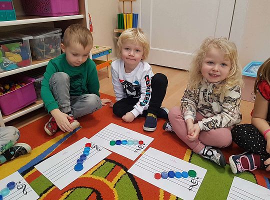 Dzieci układają zakrętki na pięciolinii