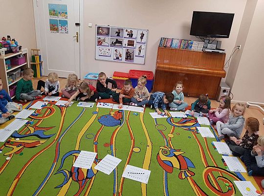 Dzieci układają zakrętki na pięciolinii