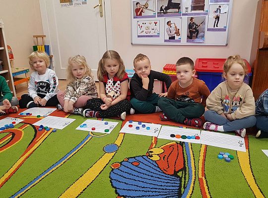 Dzieci układają zakrętki na pięciolinii